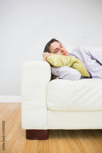 Tired businessman sleeping on sofa in living room