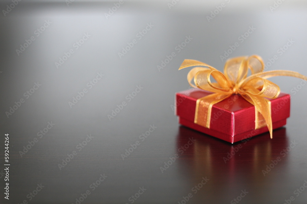 Red gift with golden ribbon on background Red gift with golden ribbon on background