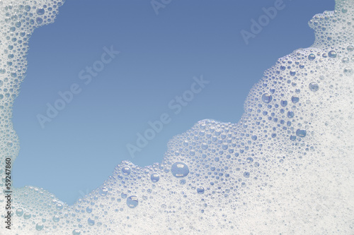 Border of bubble foam soap in blue water. photo