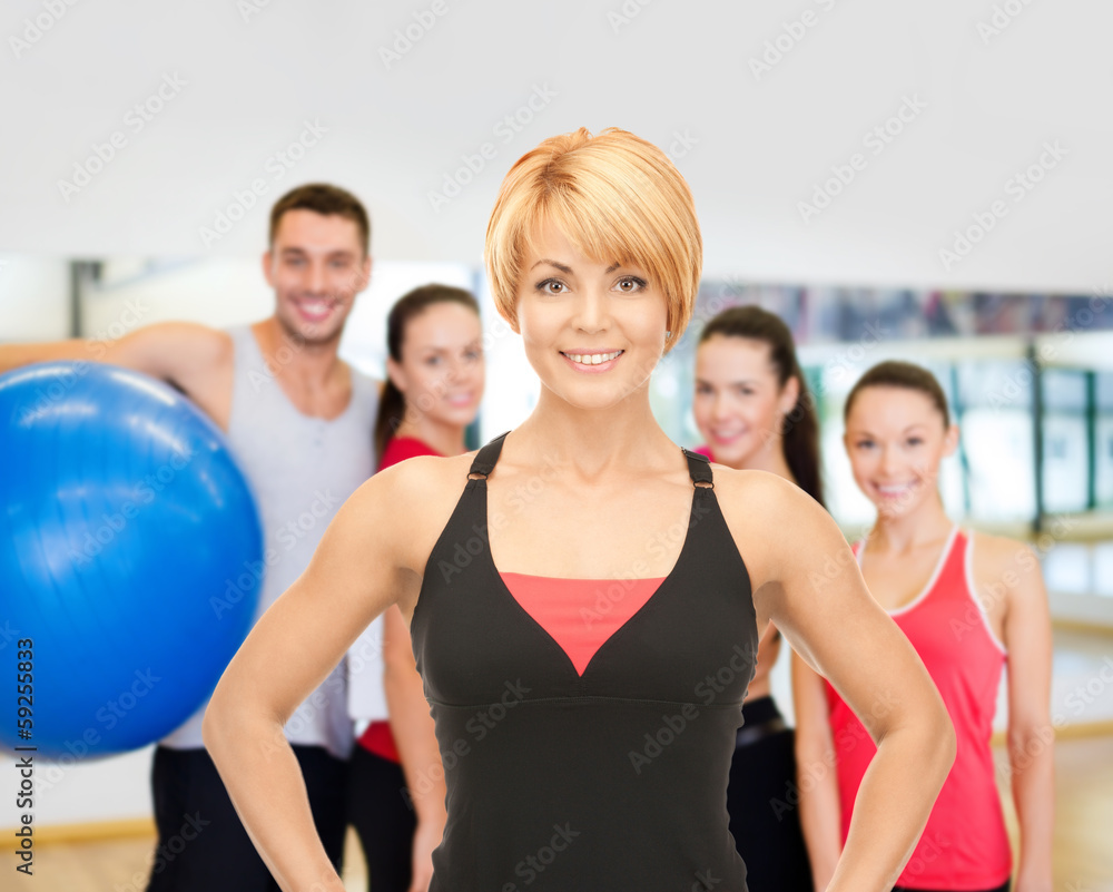 group of smiling people exercising in the gym