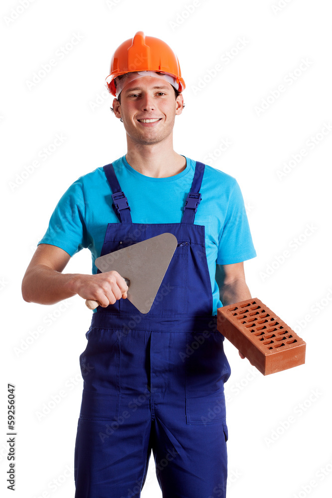 Young constructor with putty knife and brick Young constructor with putty knife and brick
