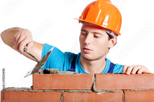 Construction mason installing red brick photo