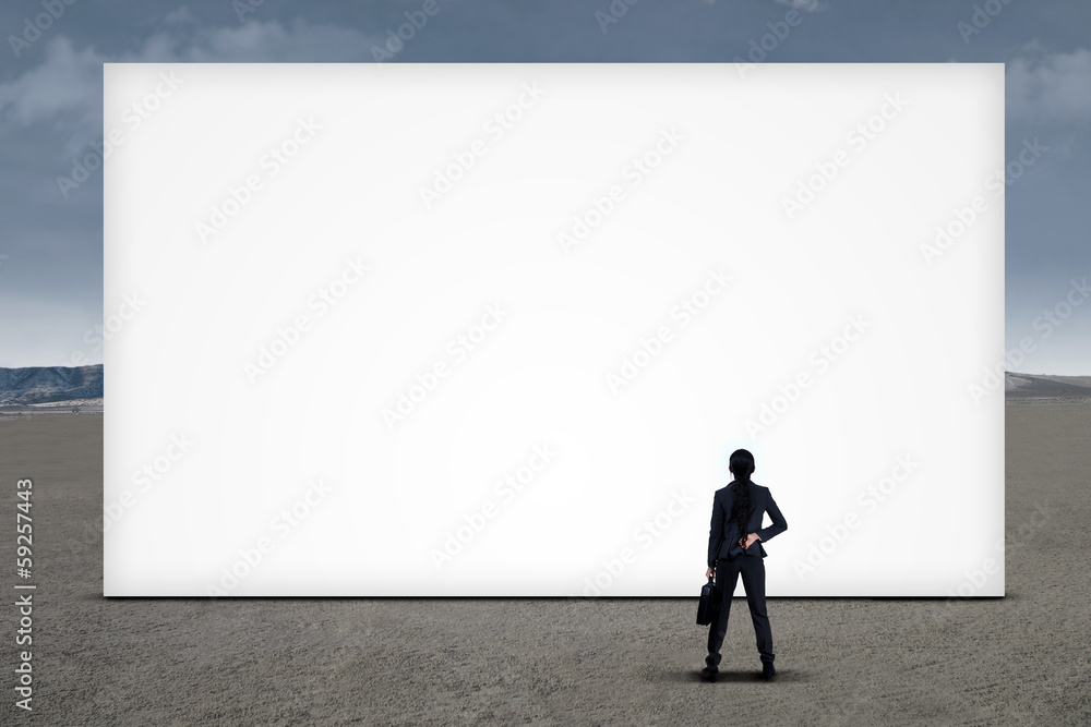 Businesswoman looking at empty board Businesswoman looking at empty board