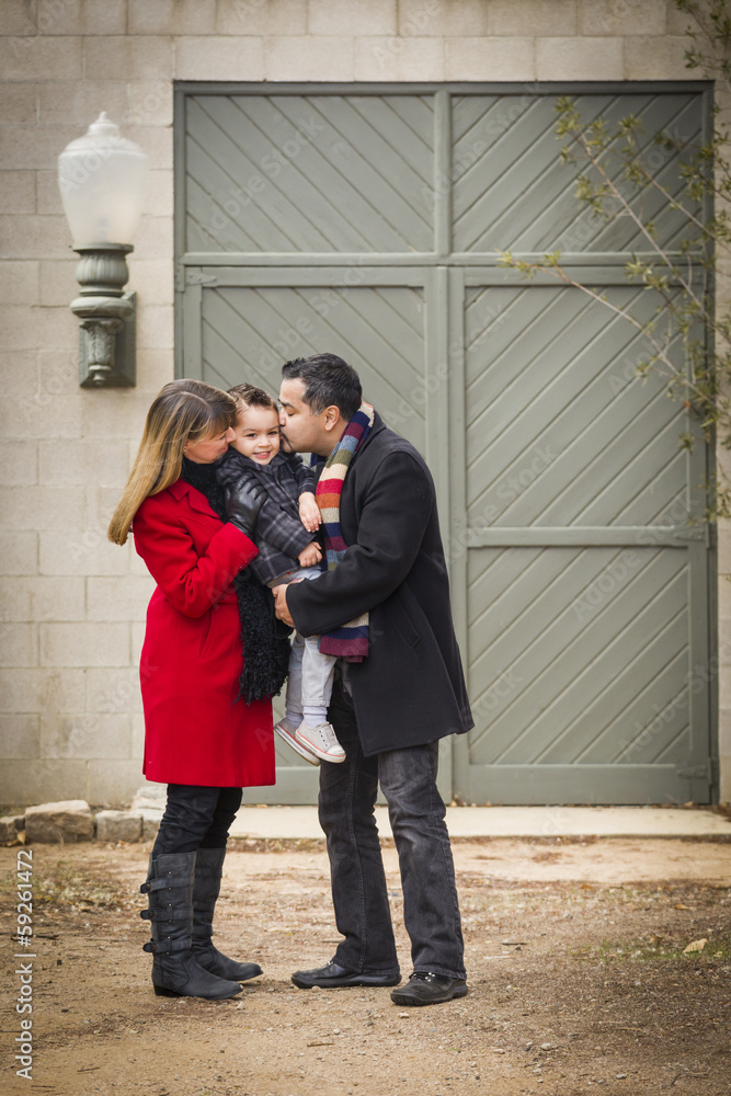 Warmly Dressed Family Loving Son in Front of Rustic Building Warmly Dressed Family Loving Son in Front of Rustic Building