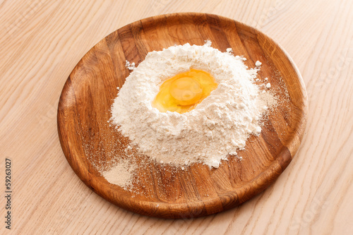 Broken egg on flour