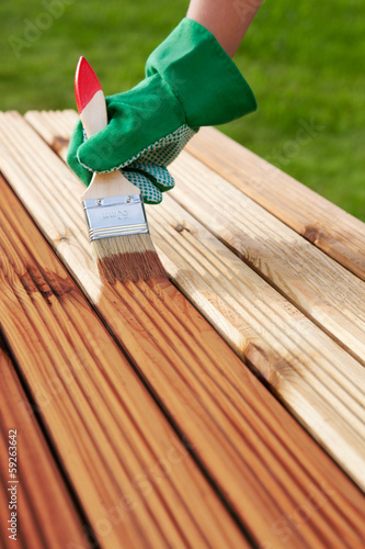 Applying protective varnish on a wooden furniture