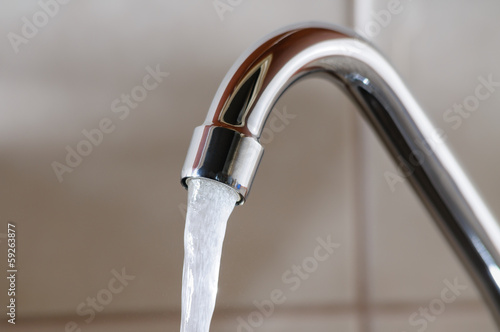 Horizontal image of a tap with water flowing normally