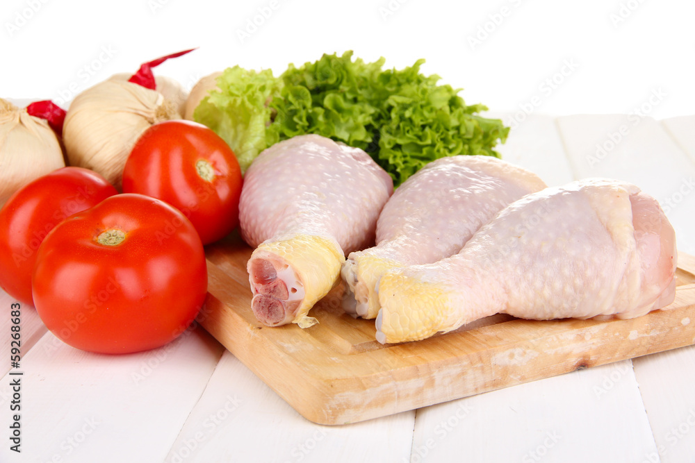 Raw chicken legs on wooden board close up Raw chicken legs on wooden board close up