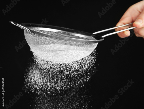 Bilde på lerret Sieve and powdered sugar on black background