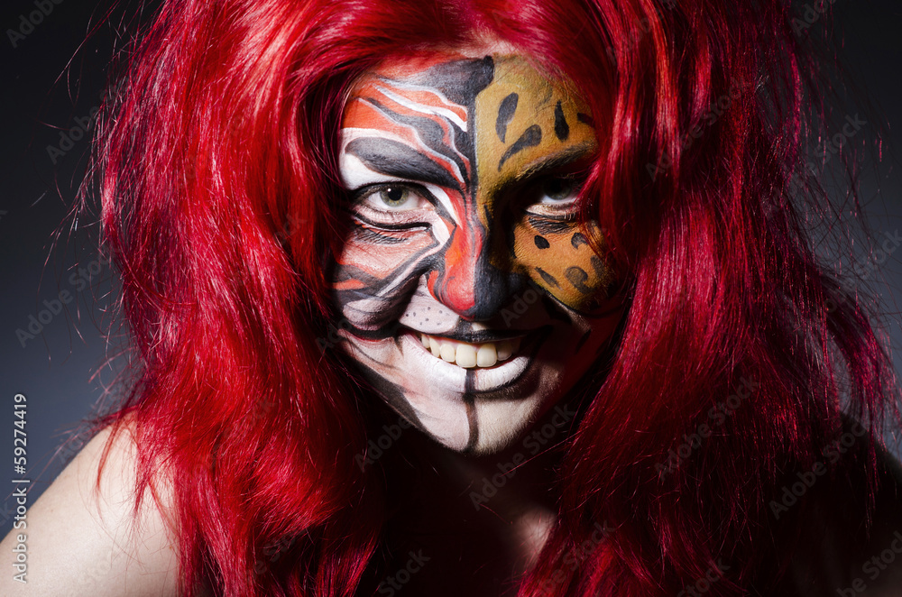 Woman with face painting in dark room Woman with face painting in dark room