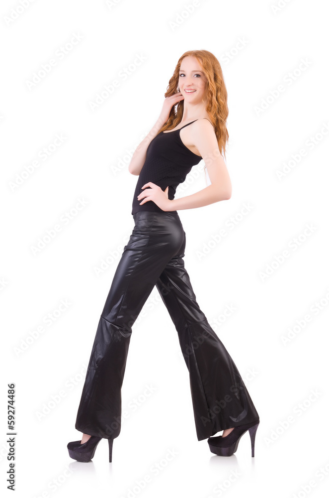 Fototapeta premium Redhead woman in black bell bottom pants on white