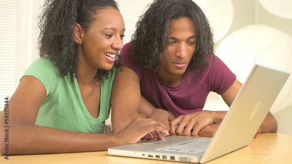 Black teen couple surfing the net on computer Black teen couple surfing the net on computer