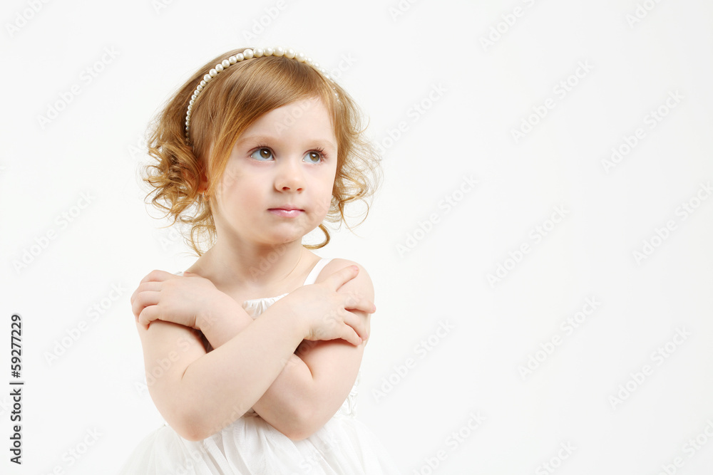 Little girl in white dress with crossed arms looks up on white Little girl in white dress with crossed arms looks up on white