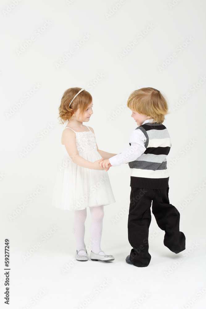 Little happy smiling girl and boy dance on white background. Little happy smiling girl and boy dance on white background.