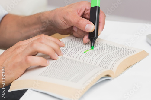 Slika na platnu Hands highlighting text in book on the table