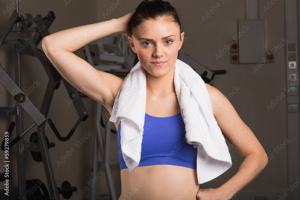 Young woman with towel standing in the gym