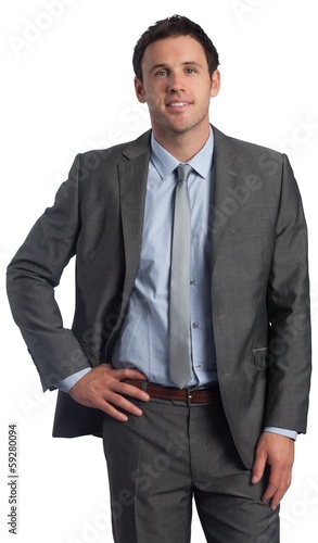 Smiling businessman with hand on hip