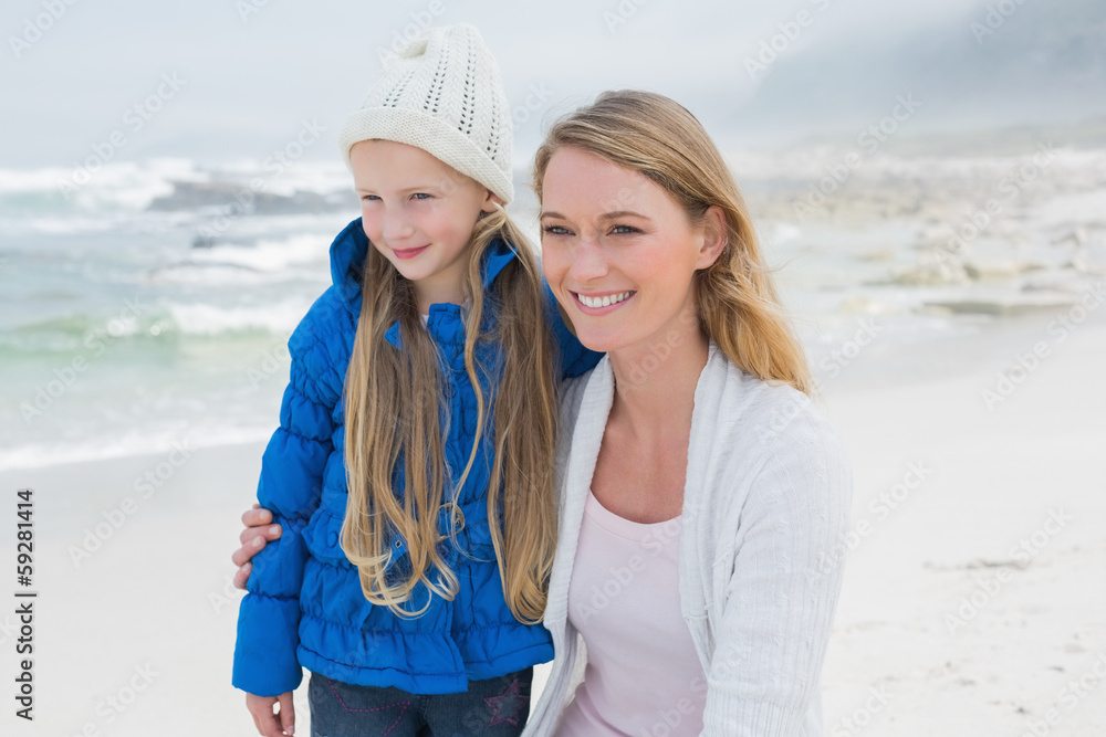 Cute girl with smiling mother at beach