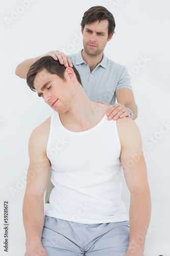 Male chiropractor doing neck adjustment © lightwavemedia