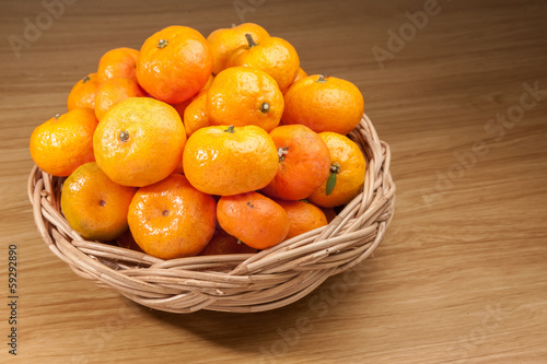 Orange fruite with basket on wood table