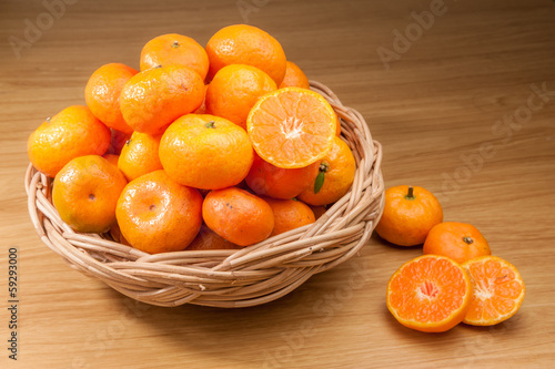 Orange fruite with basket on wood table