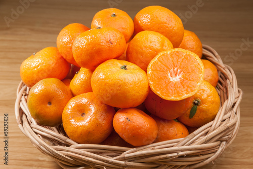 Orange fruite with basket on wood table