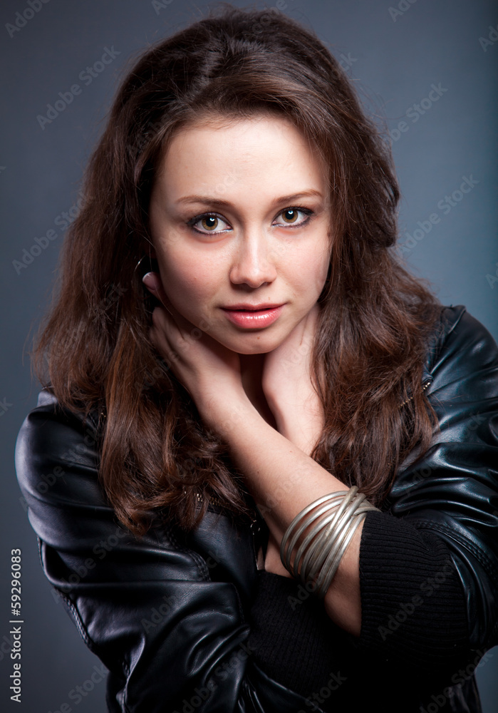 portrait of sexy brunette in leather coat holding hands on neck portrait of sexy brunette in leather coat holding hands on neck