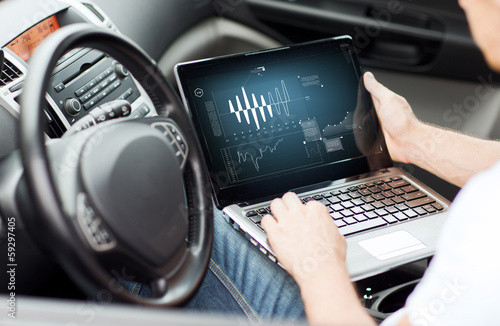 Photography man using laptop computer in car