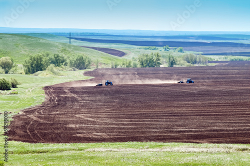 Два трактора с сеялками работают в