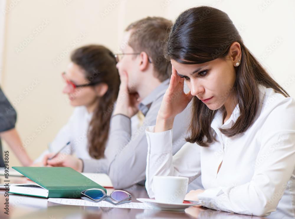 Tired business woman with headache at seminar Tired business woman with headache at seminar