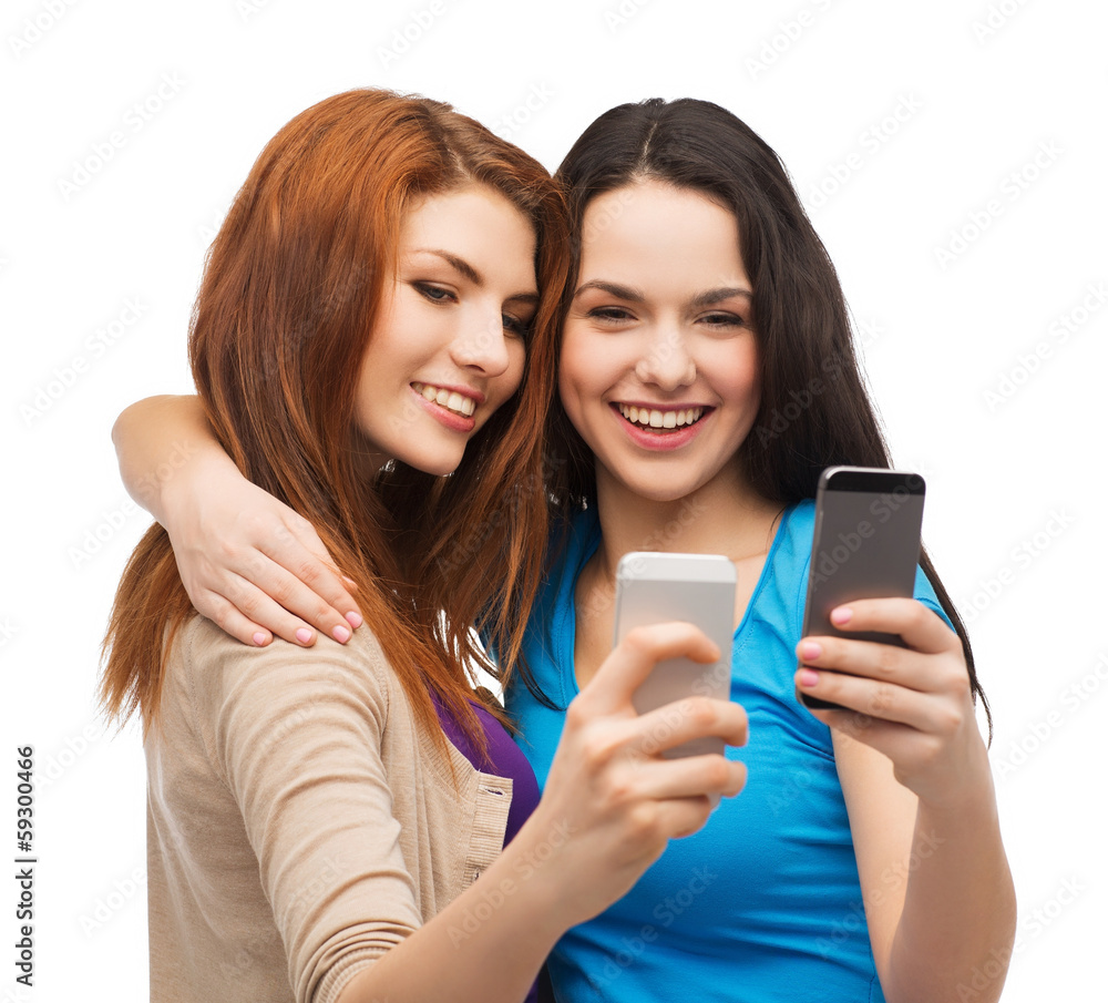 two smiling teenagers with smartphones two smiling teenagers with smartphones