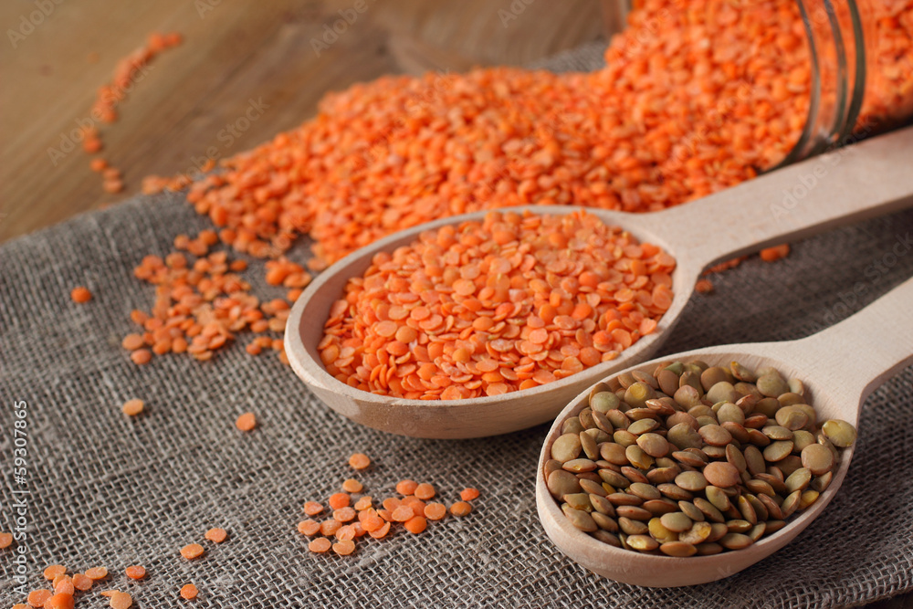 Whole green and refined red lentils in wooden spoon Whole green and refined red lentils in wooden spoon