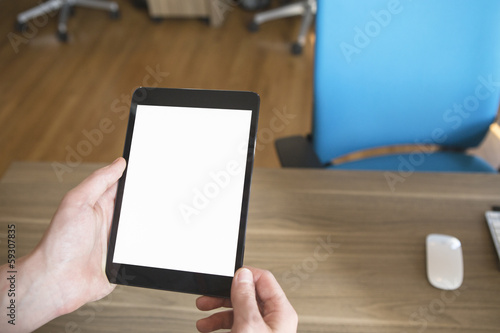 Person in the office holding a touch screen device.