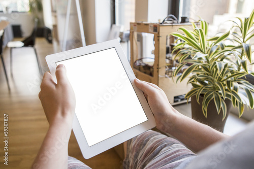 Person in the office holding a touch screen device.
