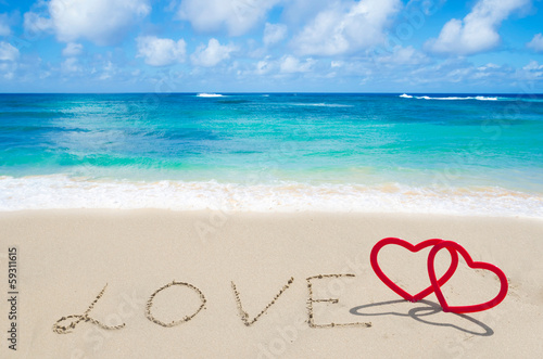Sign "LOVE" with hearts on the beach