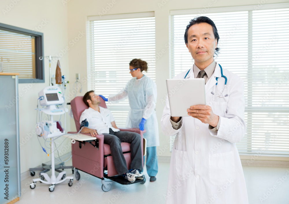 Doctor With Digital Tablet In Chemo Room Doctor With Digital Tablet In Chemo Room