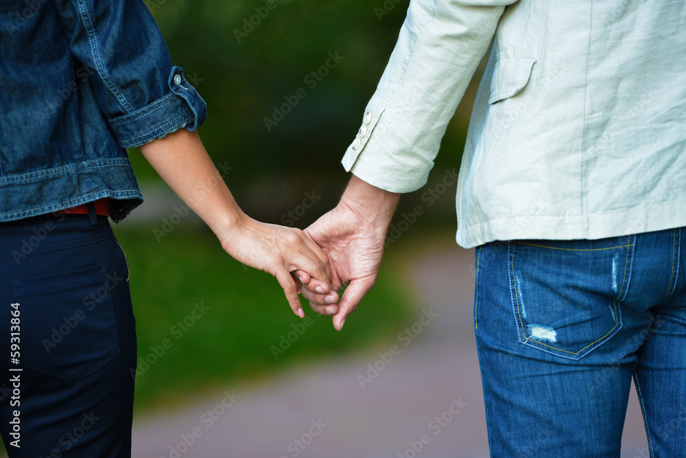 Lovely couple holding hands in the middle of summer