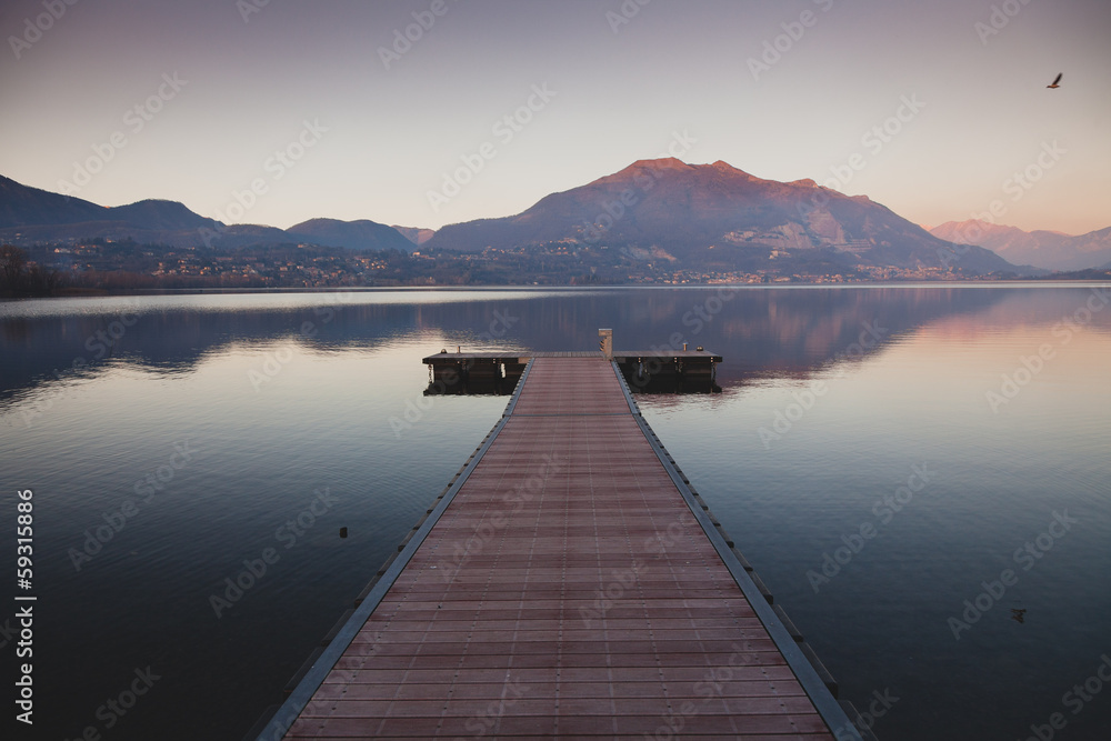 a long pier leading out onto the lake, sunrise on lake, long way