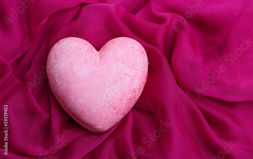 Decorative pink heart  on color fabric  isolated on white