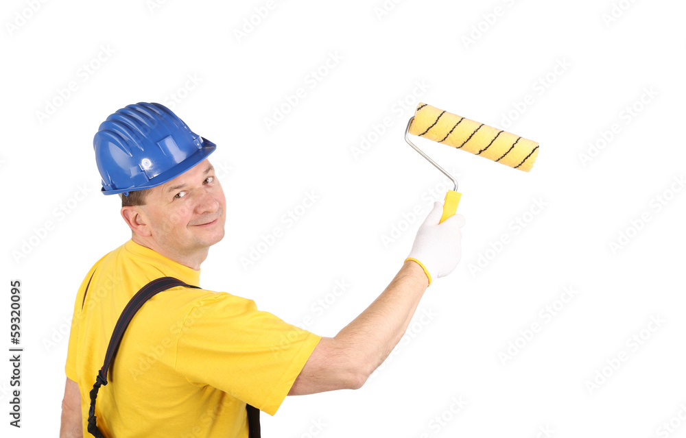 Worker in hardhat paints. Worker in hardhat paints.