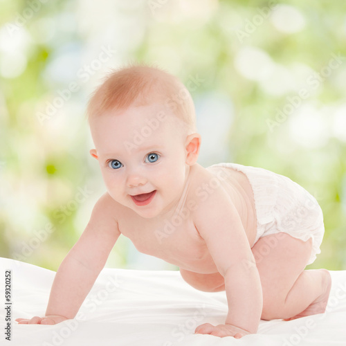 Cute baby with beautiful blue eyes on the white bed © Dmytro Sunagatov