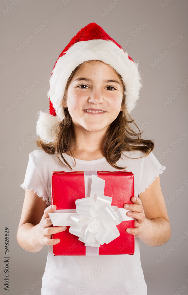 Small girl in santa hat with christmas gift Small girl in santa hat with christmas gift
