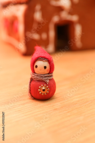 wooden figurine infront of gingerbread house © terraformer