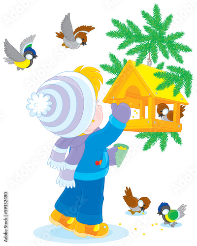 Child feeds birds in a birdfeeder