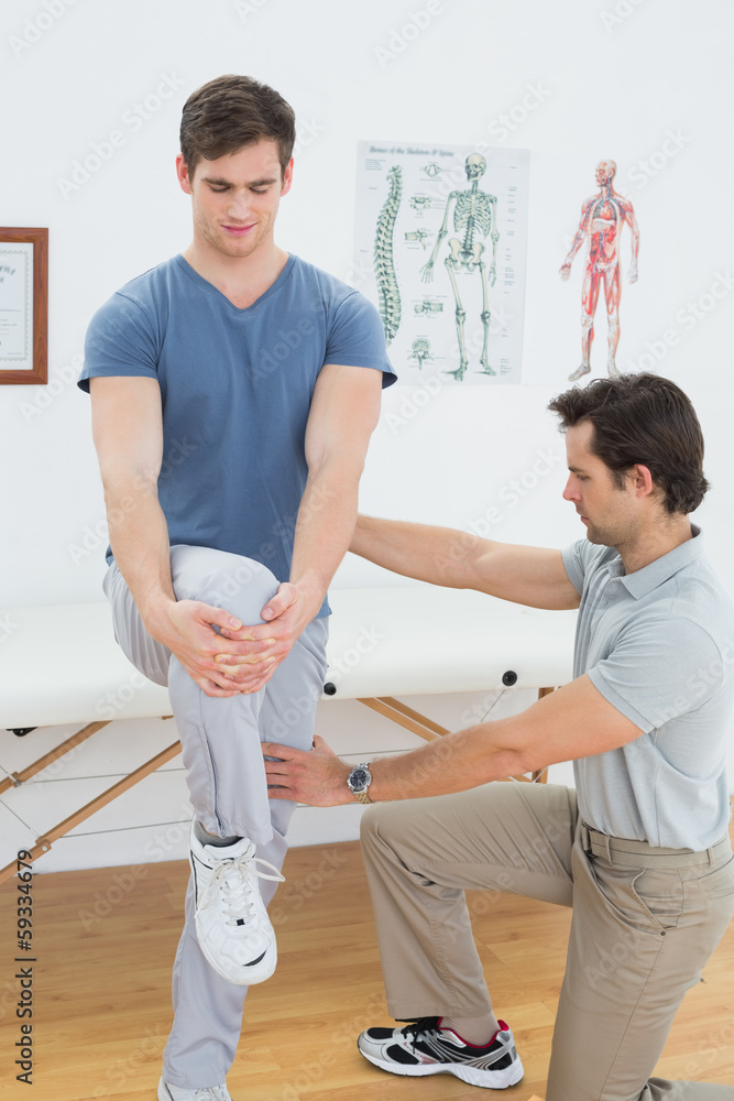 Obraz premium Male therapist assisting man with stretching exercises