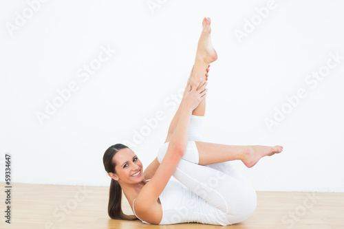 Fit woman stretching body in fitness studio