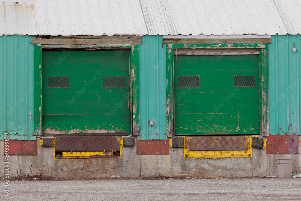 Two green shuttered outside loading gate ramps Two green shuttered outside loading gate ramps