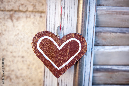 wooden heart  on a background of blue shutters
