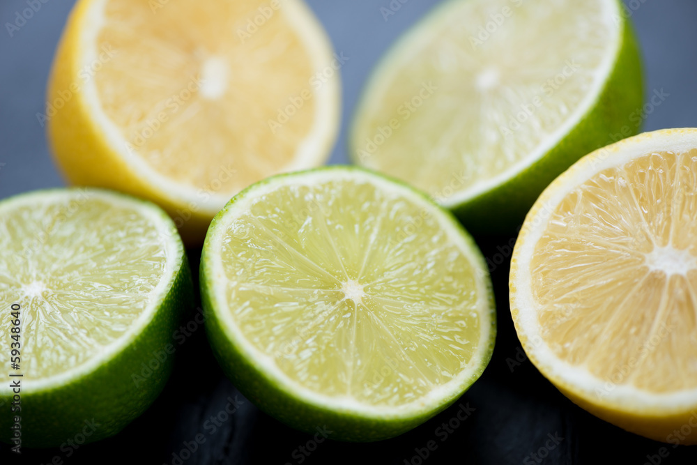 Ripe sliced limes and lemons, close-up, studio shot Ripe sliced limes and lemons, close-up, studio shot