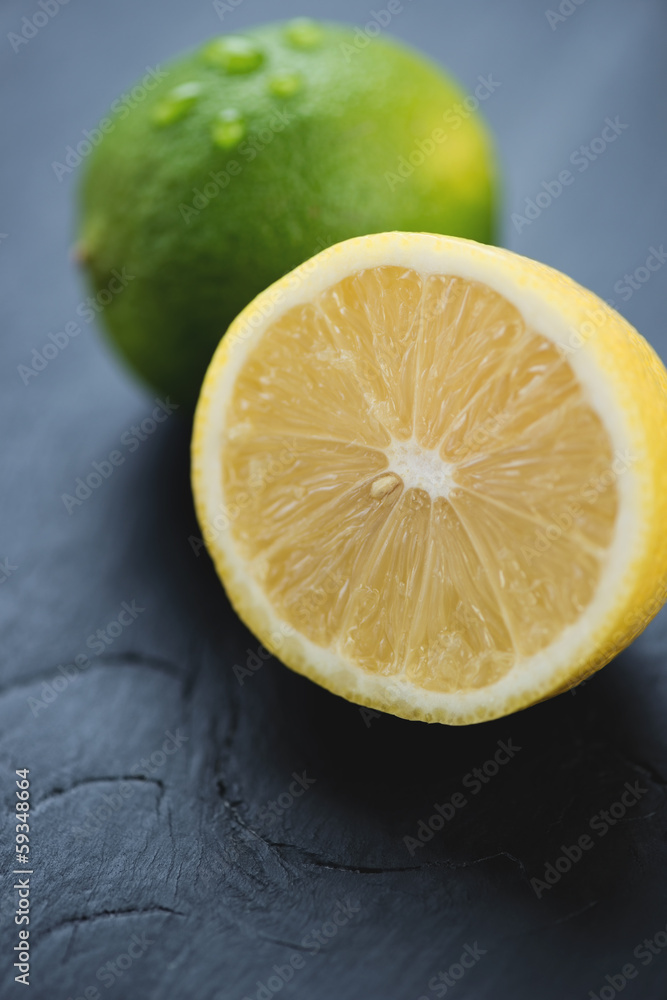 Sliced lemon and whole lime, close-up, vertical shot Sliced lemon and whole lime, close-up, vertical shot
